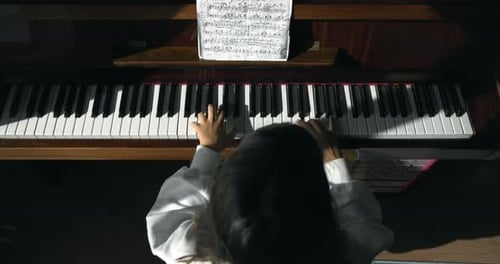 Child Plays Piano at Home Music Lesson