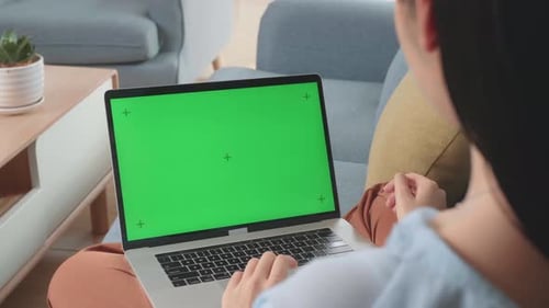 Woman Use Laptop With Green Screen Mock Up Display On Sofa