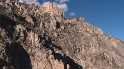 Aerial shot of mountainside cliff formations up a canyon