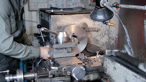 Man Working on Metal Lathe in Machine Shop