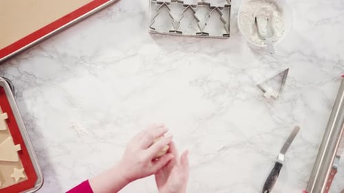 Flat lay. Cutting out sugar cookies with giant Christmas cookie cutter.