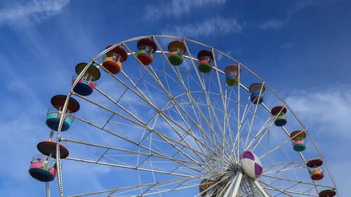Time-lapse de la grande roue au parc d'attractions avec fond de ciel bleu