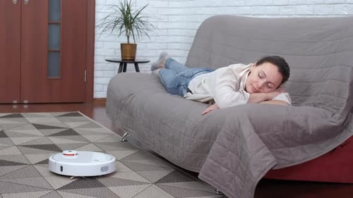 Woman Sleeping as Robot Vacuum Cleans Rug