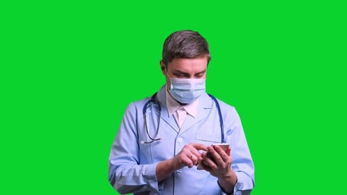 Young Doctor Using Smartphone on Green Chroma Key Background