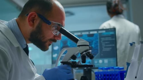 Scientist Viewing Sample Through Powerful Microscope in Lab