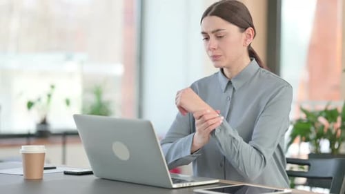 Woman Typing and Experiencing Wrist Pain in Office
