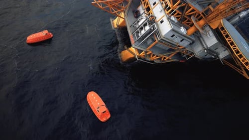 Collapsed offshore oil platform. Floating lifeboats in the sea. Oil Spill.