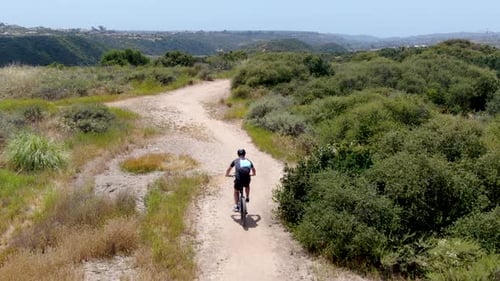 Aerial View of Riding Mountain Bike in a Small Singletrack Dry Trail in the Mountain.