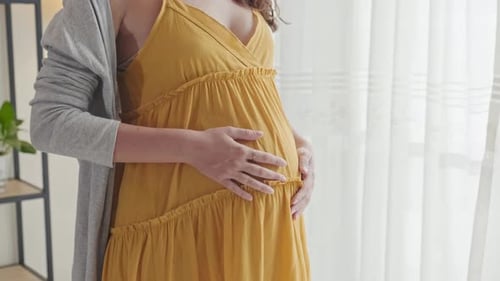 Femme enceinte caressant le ventre avec amour