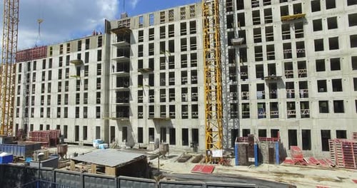 Foto aérea de un complejo residencial sin terminar con constructores trabajando