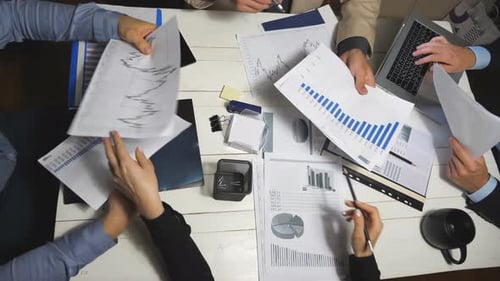 Top View Male and Female Hands of Colleagues Analyzing Financial Reports in Office. Business Team