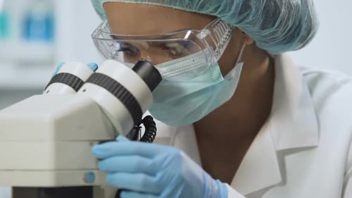 Labortechniker mit Mikroskop für mikrobiologische Analyse, Medizin