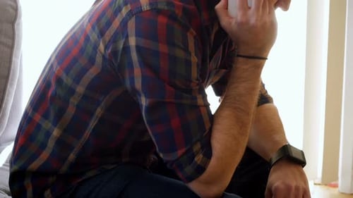 Young Adult Talking on Mobile Phone Indoors