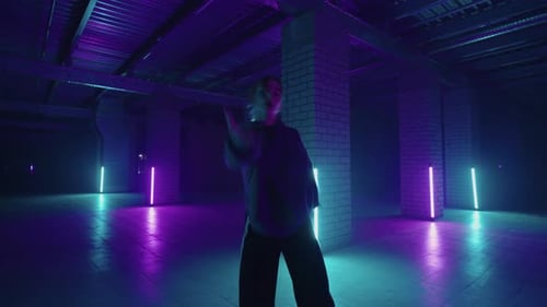 Bailarina elegante se mueve al ritmo de la música en una habitación llena de humo con iluminación de neón