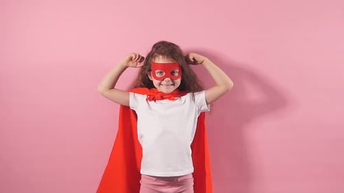 Smiling Child in Superhero Costume Flexing Muscles