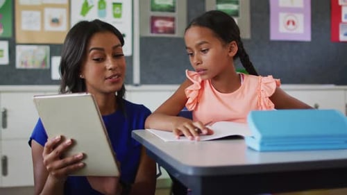 Teacher Helping Young Girl with Schoolwork