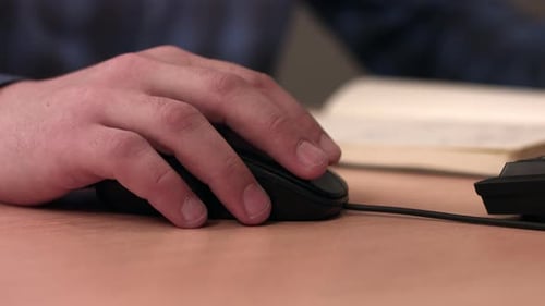 Männliche Hand auf einer Computermaus