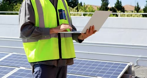 Männlicher Arbeiter benutzt Laptop an Solarstation 4k