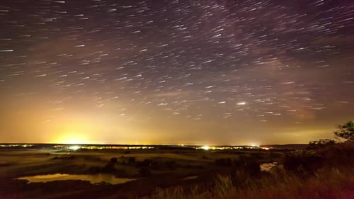 Stars Rotate Over a Rural Landscape at Night