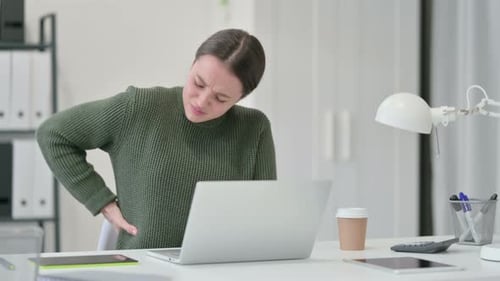 Young Woman Experiences Back Pain at Her Desk