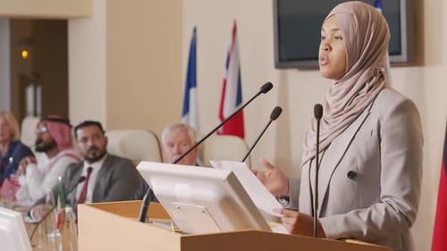 Confident Woman Giving Speech at International Conference