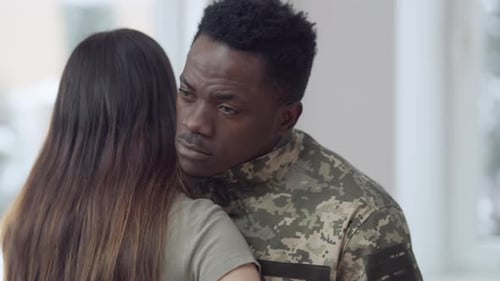 Man in Uniform Hugging A Woman Indoors