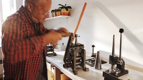 Artisan using machine on metal