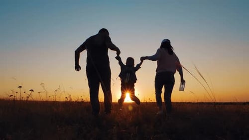 Happy Family Running into Setting Sun in Field