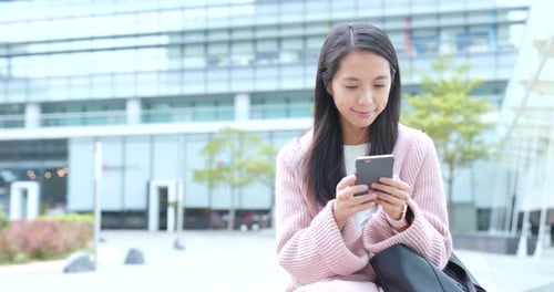 Woman Uses Smartphone in Urban Setting