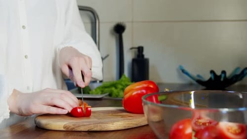Woman Cutting Red Pepper in a Bright Kitchen