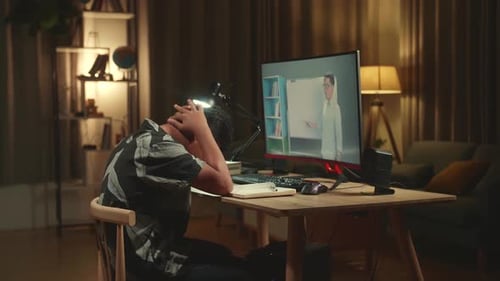 Teenage Boy Headache While Distance Learning With Online Teacher On Computer Screen From Home