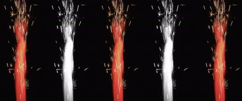 Colorful red and white fireworks burning on the black background.