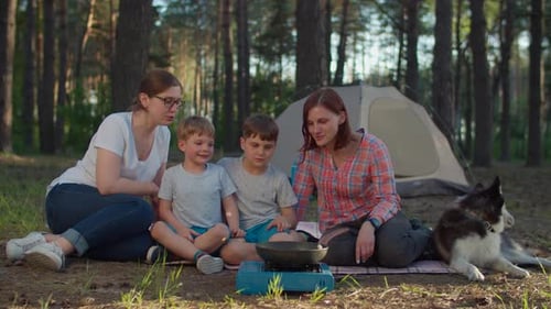 Happy Family Relaxing During Camping Trip in Forest