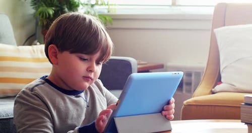 Cute Child Engrossed in Tablet at Home