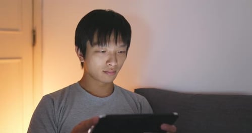 Man use of tablet computer at night