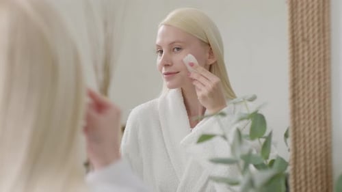 Pretty Female Doing Facial Massage in Bright Bathroom