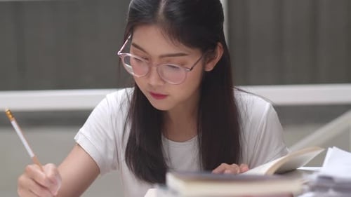 Dedicated Student Studying Hard with Book and Pencil