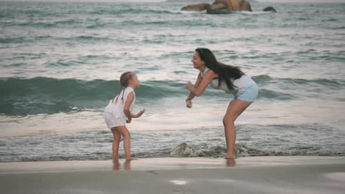Mother and Daughter Playing Together on Beach