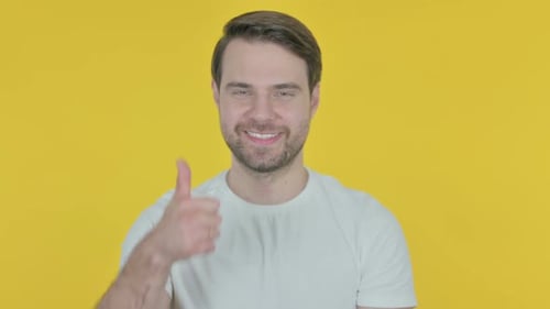 Man Gives a Thumbs Up on Yellow Background