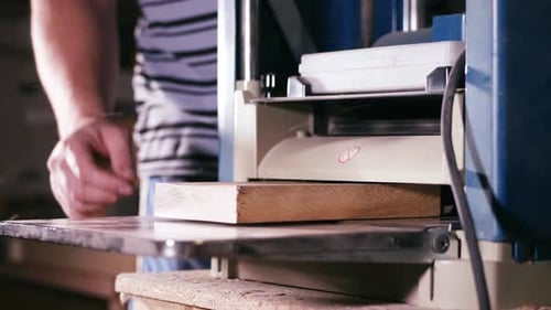 Male Carpenter is Working with Cabinet Planer Machine at Wood Workshop