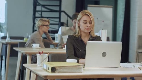 Young Woman Working on Laptop in the Office