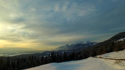 Car Driving By at Winter Mountain Sunset