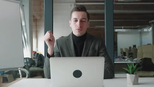 Smiling Business Man Using Laptop Computer for Video Call While Sitting at Office