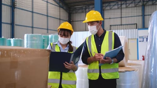 Asian factory or warehouse workers walk and check the product boxes in workplace area