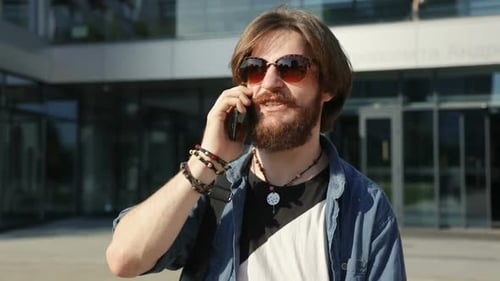 Man Talking on Phone Outside Modern Building