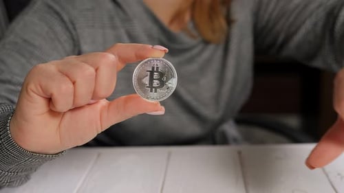 Hand Holds Bitcoin and Gives Thumbs Down