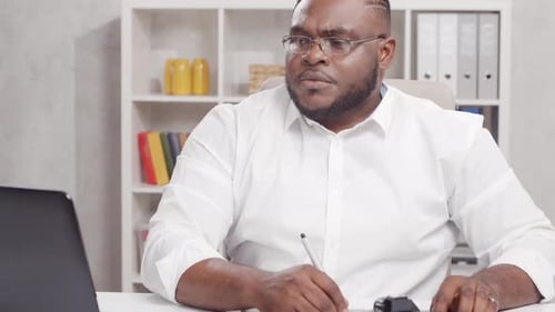 Workplace of freelance worker at home office. Young African-American man.
