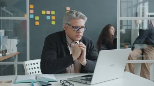 Unhappy Mature Man Office Worker Using Laptop and Feeling Failure in Workplace