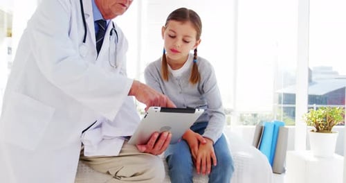 Doctor Showing Tablet to Young Girl Patient