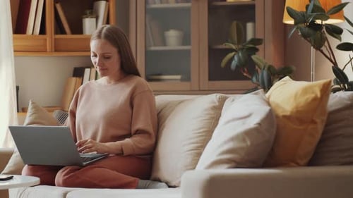Woman Working on Laptop Computer on Cozy Couch